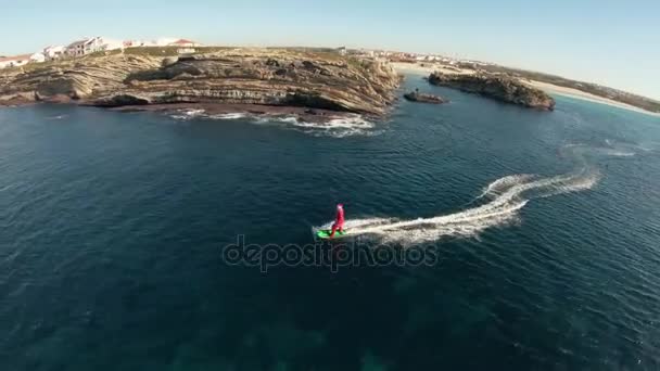 Een man in Santa Claus kostuum rijdt op jetsurf naast prachtige oceaan kust luchtfoto — Stockvideo