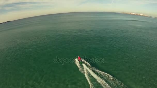 Un hombre disfrazado de Papá Noel monta en jetsurf junto a la hermosa costa del océano Vista aérea — Vídeos de Stock