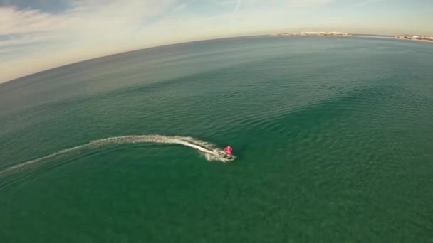 Un hombre disfrazado de Papá Noel monta en jetsurf junto a la hermosa costa del océano Vista aérea — Vídeo de stock