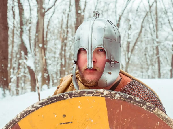 Guerrero irlandés medieval en cota de malla y casco sostiene un escudo en el bosque de invierno — Foto de Stock