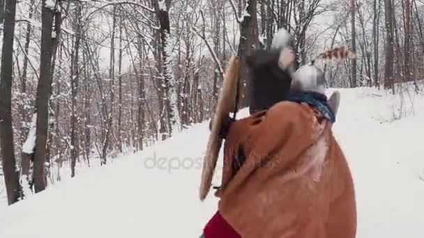 Guerreros medievales francos y vikingos en armadura luchando en un bosque invernal con espadas y escudos — Vídeos de Stock