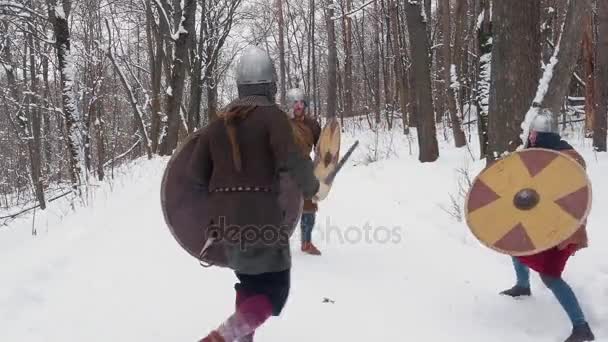 Medeltida frankish, irländska, vikingakrigare i rustning slåss i en vinter skog med svärd shields — Stockvideo