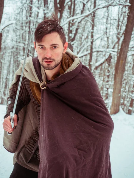 Ortaçağ viking savaşçısı zincir posta ve kask kış ormanda bir kılıç tutan