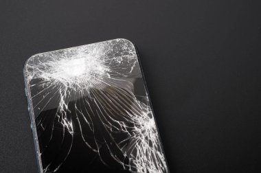 Koyu arkaplanda kırık ekranlı akıllı telefon