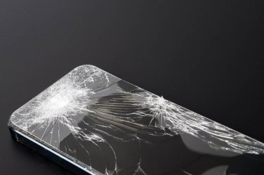Koyu arkaplanda kırık ekranlı akıllı telefon