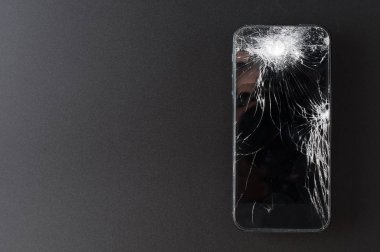 Koyu arkaplanda kırık ekranlı akıllı telefon