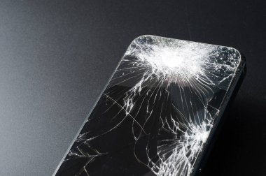 Koyu arkaplanda kırık ekranlı akıllı telefon