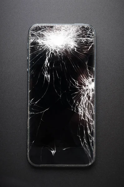Smartphone mit kaputtem Bildschirm auf dunklem Hintergrund — Stockfoto