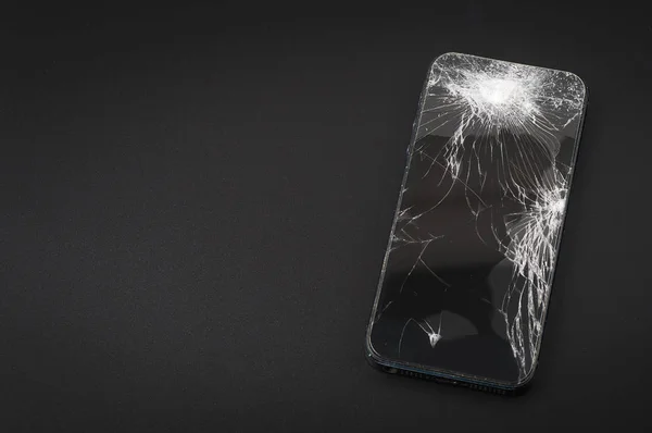 Smartphone mit kaputtem Bildschirm auf dunklem Hintergrund — Stockfoto