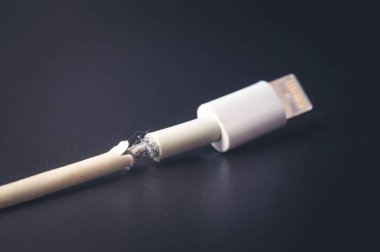 Closeup kırık akıllı telefon şarj kablosu siyah arka plan üzerine