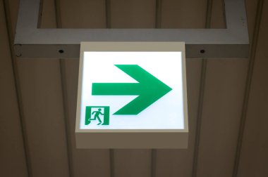 Kaçış yolunu gösteren yeşil acil çıkış işareti.