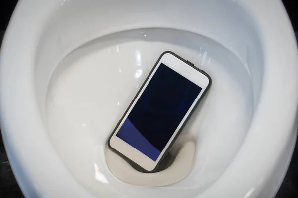 A white smartphone dropped into a toilet bowl — Stock Photo, Image