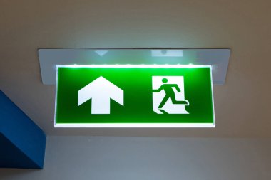 Kaçış yolunu gösteren yeşil acil çıkış işareti.