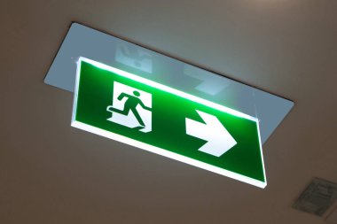 Kaçış yolunu gösteren yeşil acil çıkış işareti.