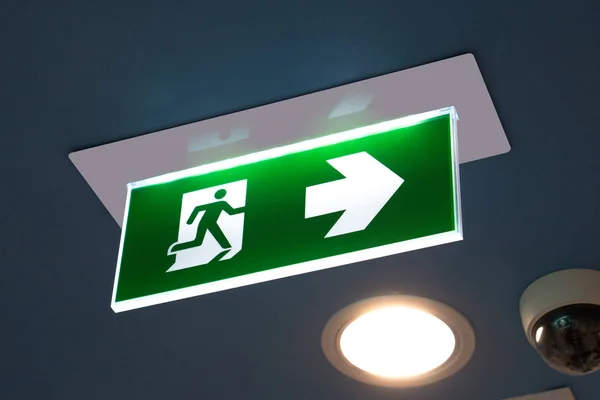 Señal verde de salida de emergencia que muestra el camino para escapar . — Foto de Stock