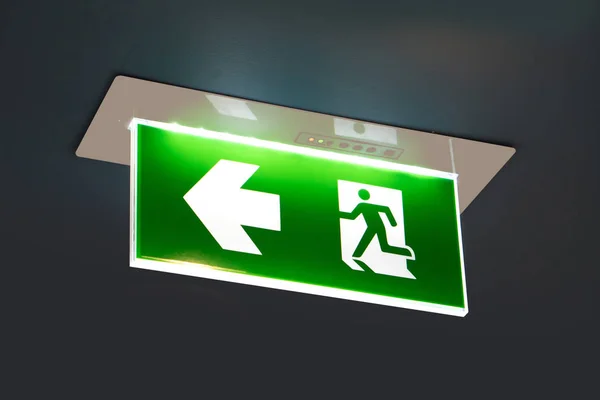 green emergency exit sign showing the way to escape.