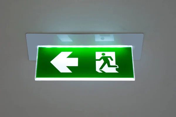 green emergency exit sign showing the way to escape.