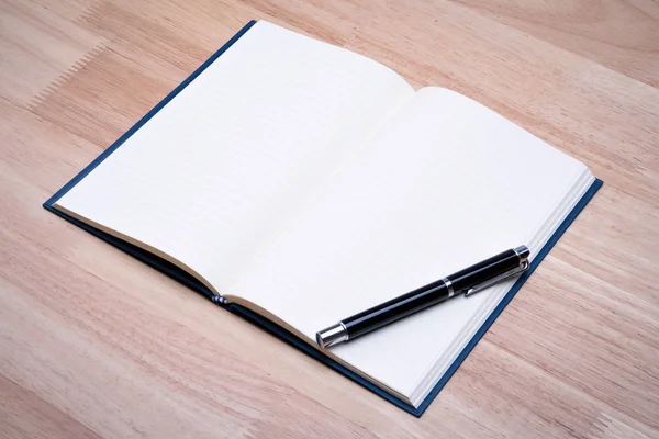 Άνοιγμα κενό χαρτί σημειωματάριο δερμάτινο με στυλό ξύλινο τραπέζι. — Φωτογραφία Αρχείου