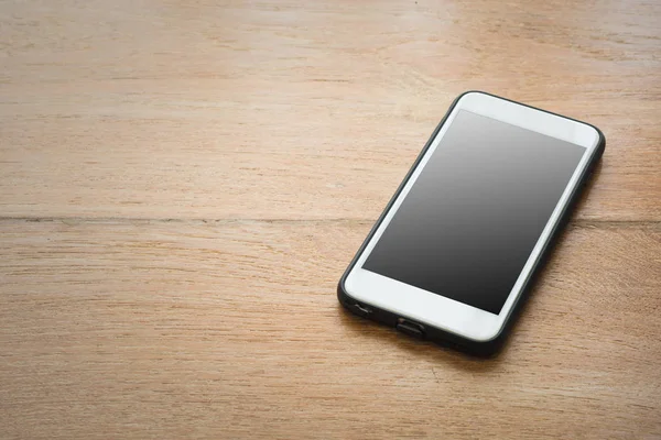 Smartphone mit leerem Bildschirm auf Holz-Hintergrund. — Stockfoto