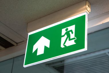 Kaçış yolunu gösteren yeşil acil çıkış işareti.