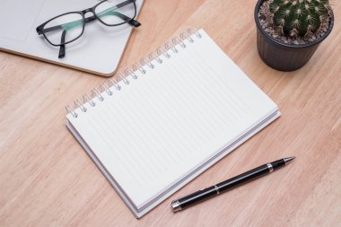 Boş defter kalem üzerinde ahşap masa, iş kavramı ile.