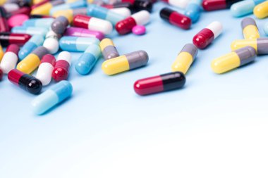 birçok mavi arka plan üzerinde renkli hapları dağınık.