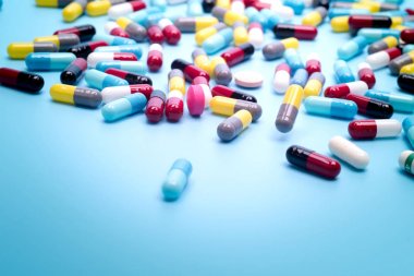 birçok mavi arka plan üzerinde renkli hapları dağınık.