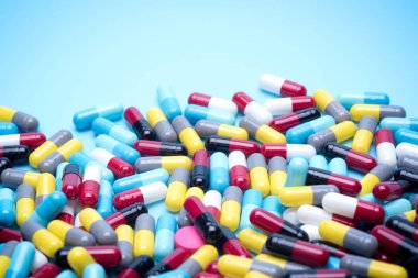 birçok mavi arka plan üzerinde renkli hapları dağınık.