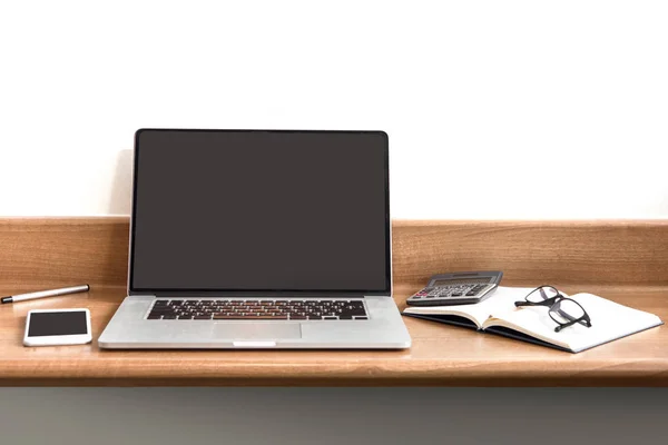 Werkplek met opengeklapte laptop met zwart scherm op moderne houten de — Stockfoto