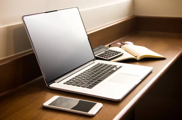 Werkplek met opengeklapte laptop met zwart scherm op moderne houten de — Stockfoto