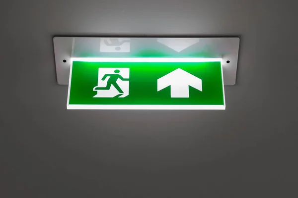 Зеленый знак аварийного выхода, указывающий путь эвакуации . — стоковое фото