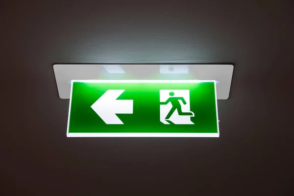 Zöld vészkijárati tábla mutatja az utat a meneküléshez.. — Stock Fotó
