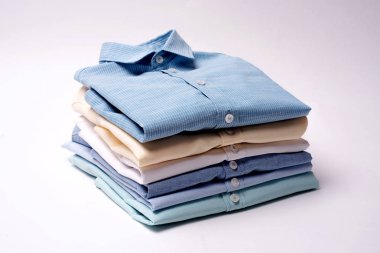 Klasik erkek gömlek beyaz zemin üzerine yığılmış.