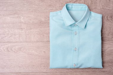 Yeni mavi gömlek uzun ahşap arka plan üzerinde.