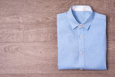 Yeni gömlek üzerinde ahşap arka plan mavi.