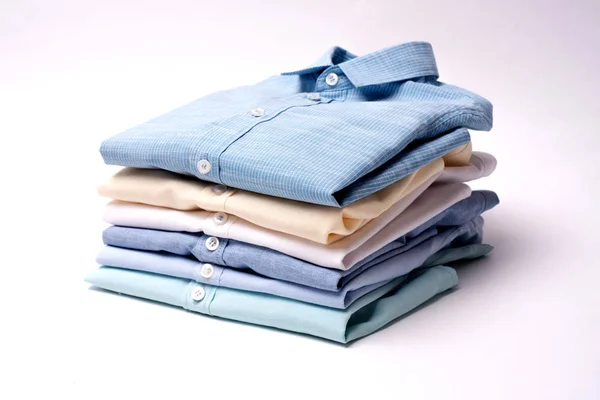 Classic men's shirts stacked on white background. Stock Picture