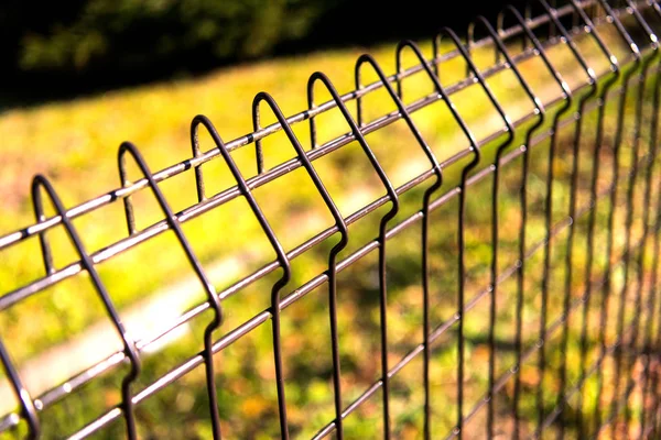 Çelik ızgara futbol sahası, çim ile Metal çit tel çit — Stok fotoğraf