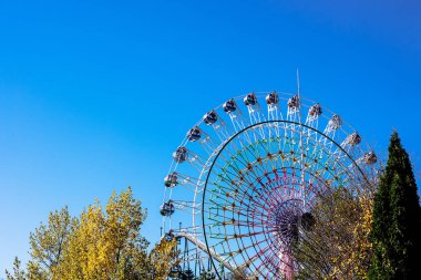 Mavi gökyüzünün arka planında dönme dolap.