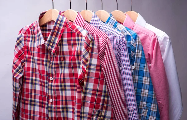 Pila de varias camisas de cuadros de los hombres sobre fondo gris . — Foto de Stock