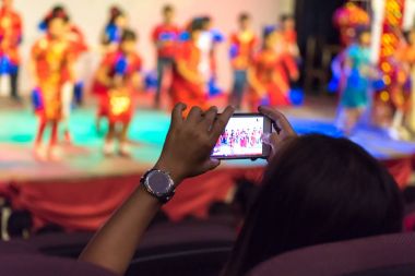 kadın sahne fotoğraf çekmek için cep telefonu kullanarak