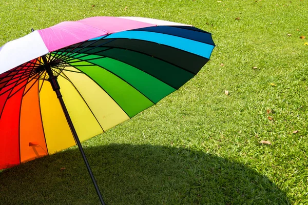 Guarda-chuva arco-íris no campo de grama vintage e tom retro, foc macio — Fotografia de Stock
