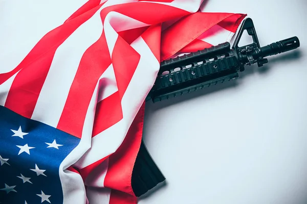 Bandera americana con pistola sobre fondo blanco — Foto de Stock