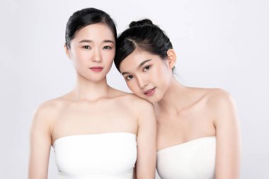 Portre. İki güzel Asyalı kadın. Taze, çıplak deri konsepti. Asyalı güzel kız cilt bakımı ve sağlık, yüz bakımı, mükemmel cilt, doğal makyaj, beyaz arka plan..