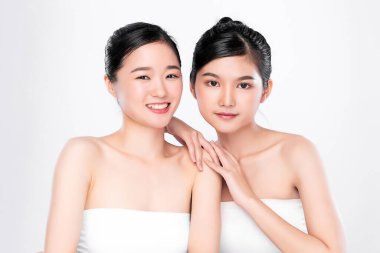 Portre. İki güzel Asyalı kadın. Taze, çıplak deri konsepti. Asyalı güzel kız cilt bakımı ve sağlık, yüz bakımı, mükemmel cilt, doğal makyaj, beyaz arka plan..