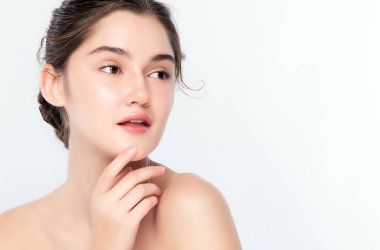 Güzel, genç bir kadın temiz yüzüne dokunuyor. Sağlıklı cilt, beyaz arka planda izole edilmiş güzellik kozmetik ve yüz bakımı konsepti..