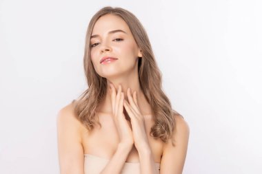 Güzel, genç bir kadın temiz yüzüne dokunuyor. Sağlıklı cilt, beyaz arka planda izole edilmiş güzellik kozmetik ve yüz bakımı konsepti..