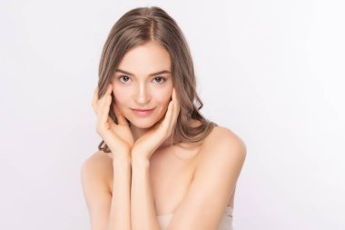 Güzel, genç bir kadın temiz yüzüne dokunuyor. Sağlıklı cilt, beyaz arka planda izole edilmiş güzellik kozmetik ve yüz bakımı konsepti..