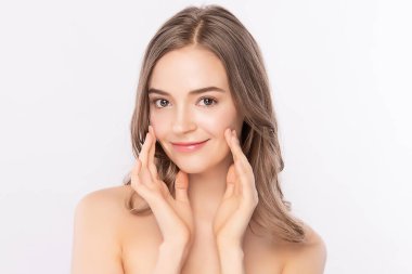 Güzel, genç bir kadın temiz yüzüne dokunuyor. Sağlıklı cilt, beyaz arka planda izole edilmiş güzellik kozmetik ve yüz bakımı konsepti..