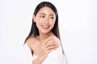 Güzel, genç Asyalı bir kadın vücuduna yeni sağlıklı bir ciltle dokunuyor, beyaz arka planda izole edilmiş, güzellik estetiği ve yüz bakımı konsepti..