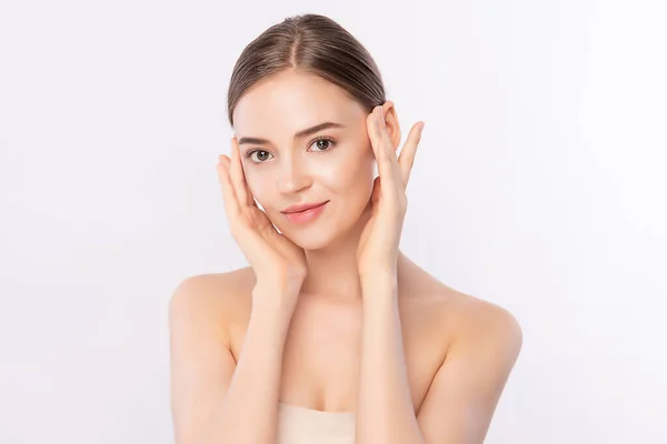 Güzel, genç bir kadın temiz yüzüne dokunuyor. Sağlıklı cilt, beyaz arka planda izole edilmiş güzellik kozmetik ve yüz bakımı konsepti.